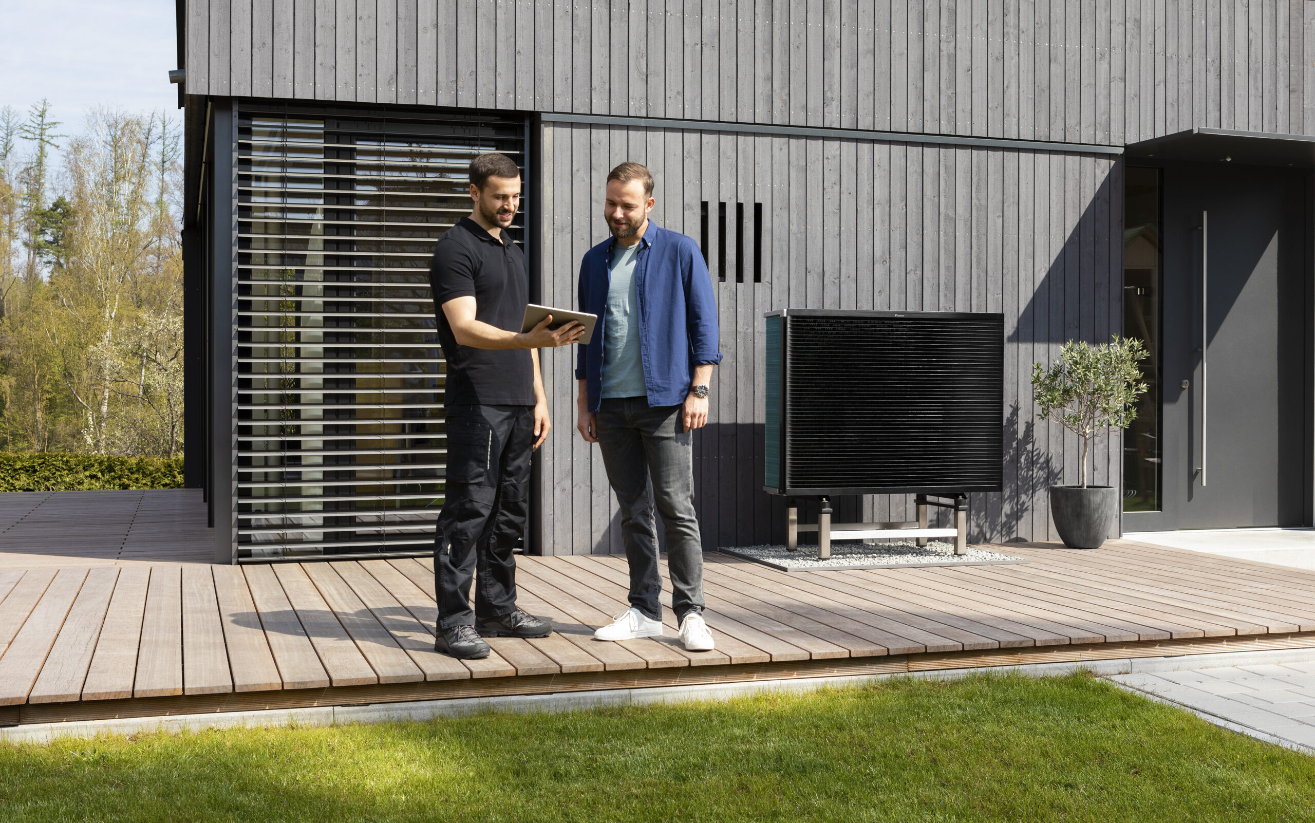 Techniker erläutert die Funktion einer Wärmepumpe vor Ort beim Kunden – symbolisch für Photovoltaik- und Heizungsförderung 2025.